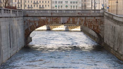 old stone arch bridge norrbro over flowing water in stockholm, sweden, static shot