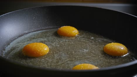 putting spices mushrooms, cheese and other ingridients on fried eggs in pan