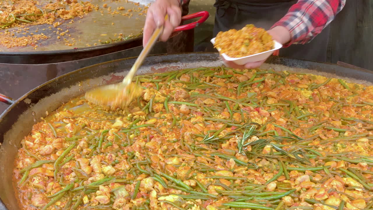 paella de pollo y verduras servida desde una sartén grande en una bandeja de plástico en un mercado callejero de edimburgo, edimburgo, lothian, reino unido
