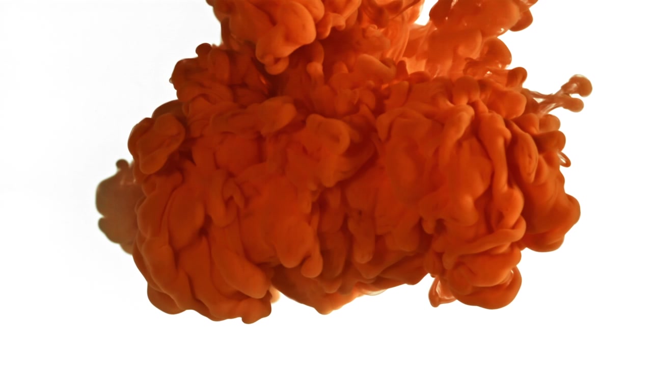 Levende orange blæk, der spreder sig og opløses i vand