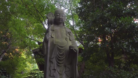 it is very common to see different statues in the buddhist temples of tokyo and kyoto surrounded by intense green nature and a hot summer.