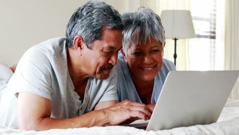 senior couple using laptop in bedroom 4k