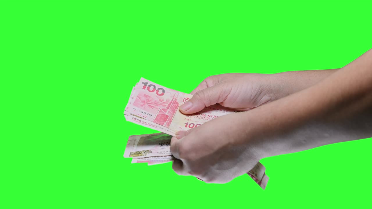 초록색 화면 배경에 고립된 홍콩 100달러 지폐를 들고 있는 손.
