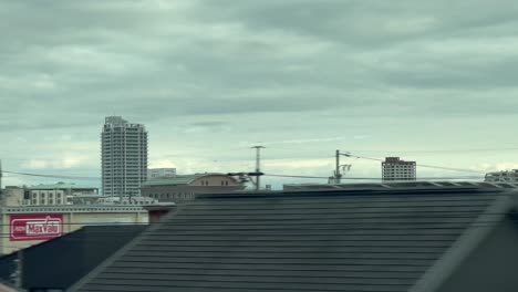 traveling bullet train through residential neighbourhood between kyoto and tokyo in japan