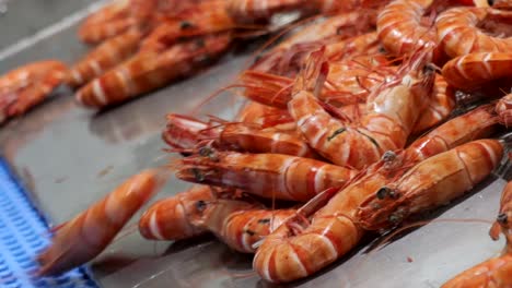 fresh caught prawns slide down conveyor belt onto the processing line, highlighting the care and cleanliness involved in preparing premium produce.