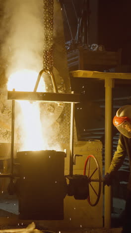 trabajadores de la fábrica de acero que operan un alto horno con una poderosa explosión de llamas
