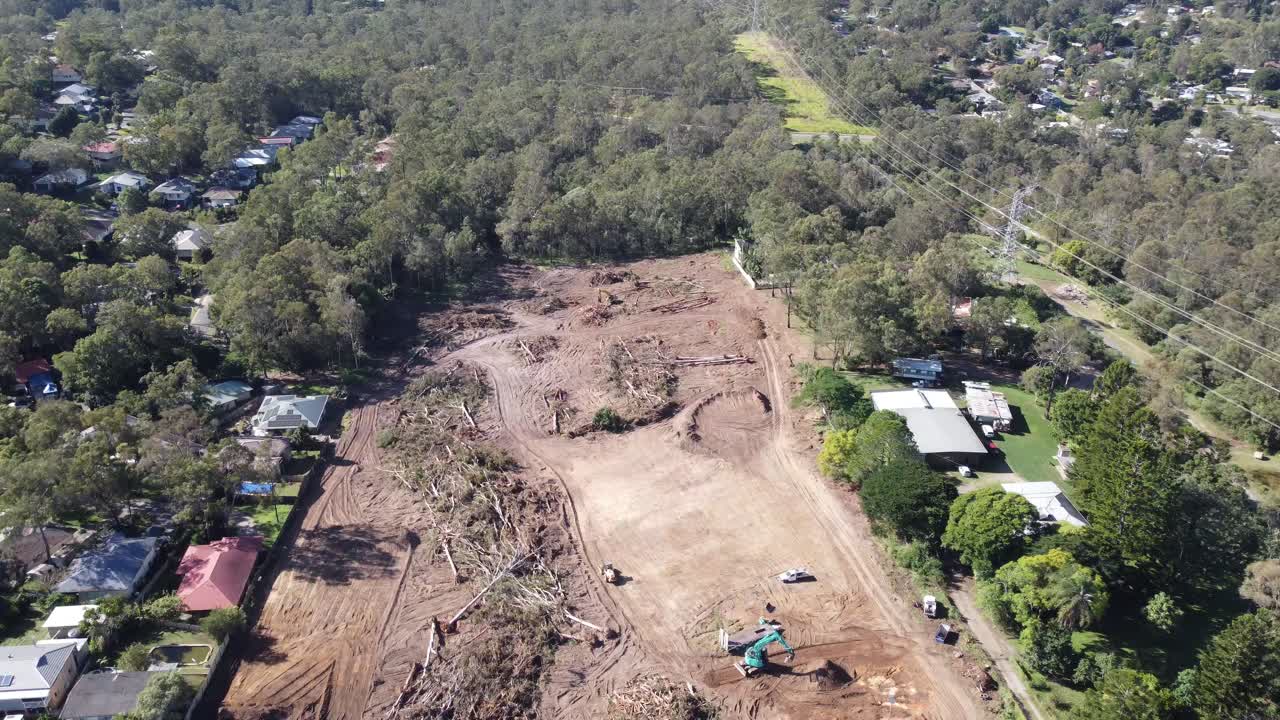 Drone flying over a worksite with heavy machinery clearing land from trees for a new subdivision in Australia
