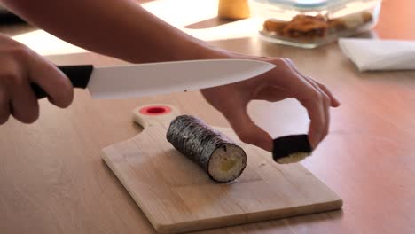 cutting down a sushi roll in the kitchen