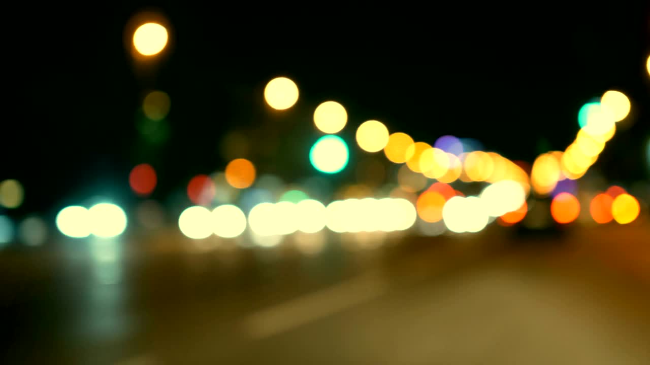 conducir un coche a través de la carretera de la noche, la autopista. luces desenfocadas calle de los ángeles resumen. ciudad fondo borroso. movimientos círculos bokeh de tráfico nocturno.