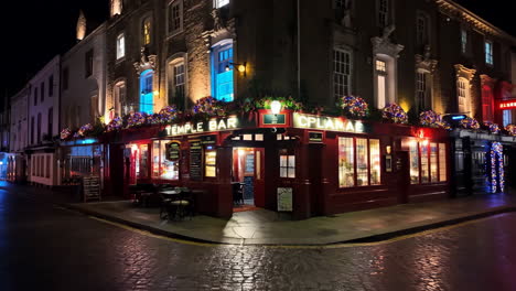 temple bar pub illuminated at night on a cobblestone street in london