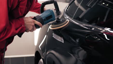 mecánico de automóviles pulido un coche negro nuevo limpiando el vehículo nuevo.