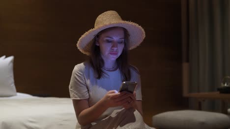 A-close-up-shot-of-a-beautiful-girl-relax-sit-on-bed-at-home-using-cellphone-texting-chatting-with-friend