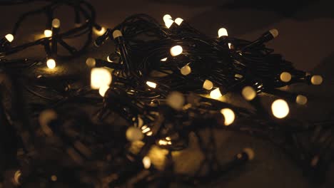 Close-up shot hank of christmas garland with golden lights on a playd. Christmas concept. Home decor
