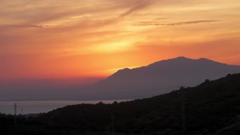 sun setting behind the mountains near marbella, spain