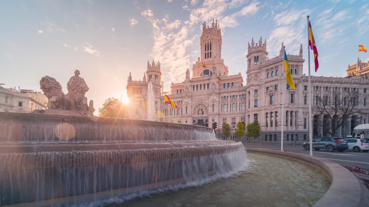 Early morning timelapse of Cibeles fountain and Madrid town hall with traffic and beautiful clouds and mornig light