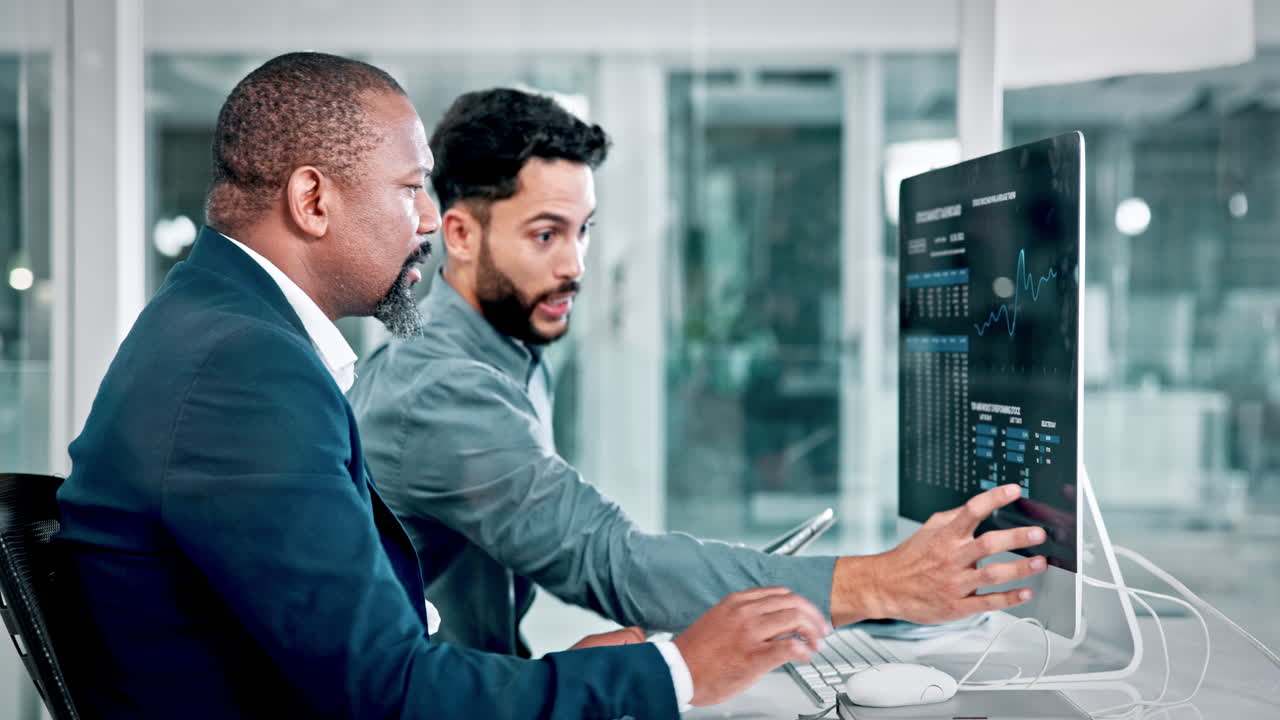Professional Men Discussing Business Data on a Computer in an Office