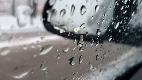 rainy day in a car. rain drops flowing down on a car window and other cars passing by