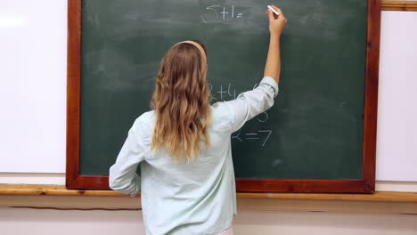 teacher writing mathematics on board