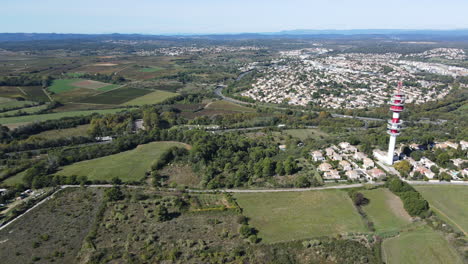 antenna amidst green pastures and residential backdrop.