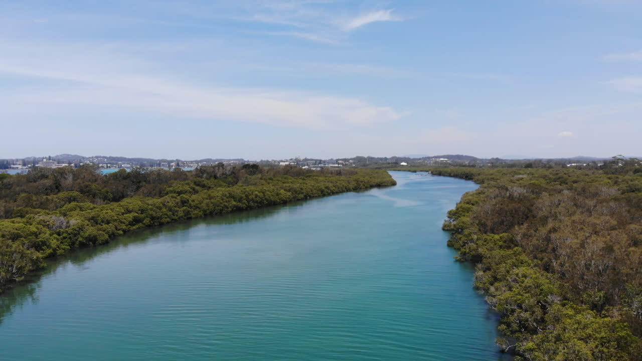 volando sobre el canal del río hastings en la reserva natural de weargore australia durante un hermoso día de verano, árboles y bosques verdes en ambos lados