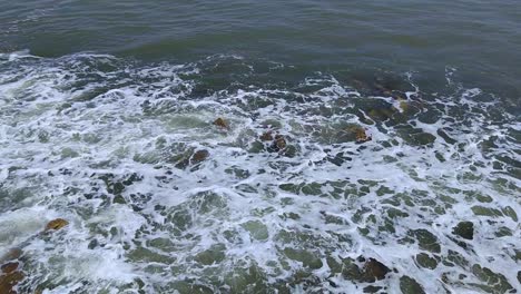 Pequeñas-Olas-De-Agua-De-Mar-Golpeando-Piedras-Marrones,-Luz-Del-Día,-Full-Hd