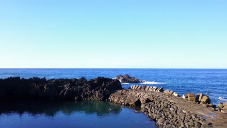 aerial forward over seixal stone pier in madeira island