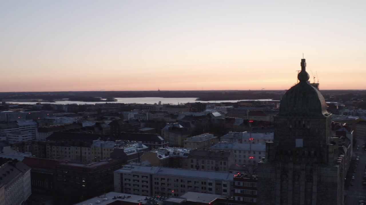 Drone shot rotate around high church dome in city center of Helsinki at sunset