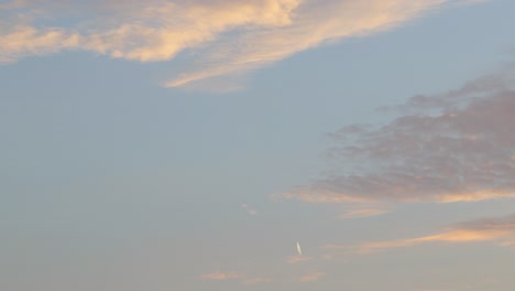 Distant-airplane-flying-up-in-the-sky-during-sunset