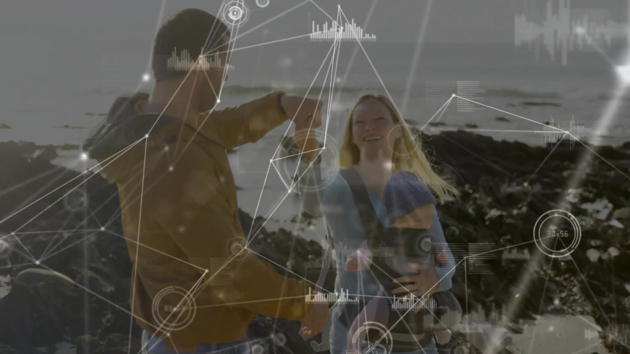 Man raising arm, taking woman's hand, twirling woman and infant bonding on shore with tech overlays