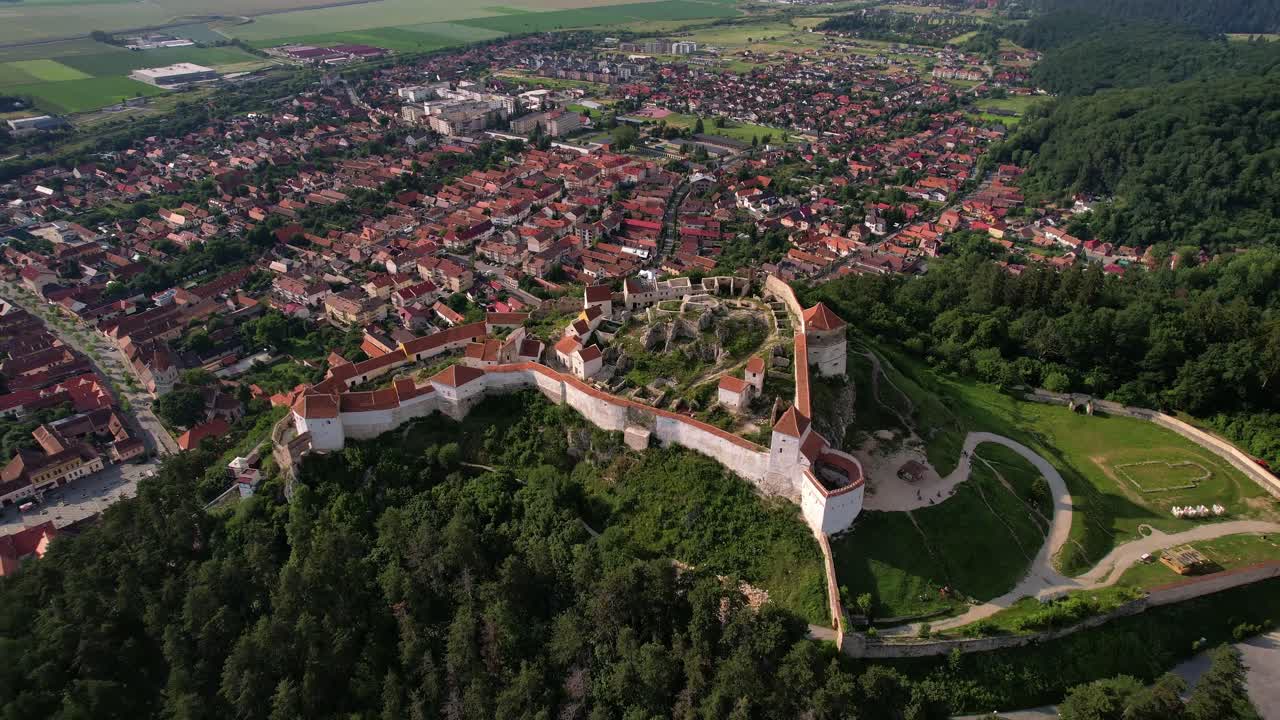 Rasnov citadel in romania with town and green landscape in daylight, aerial view