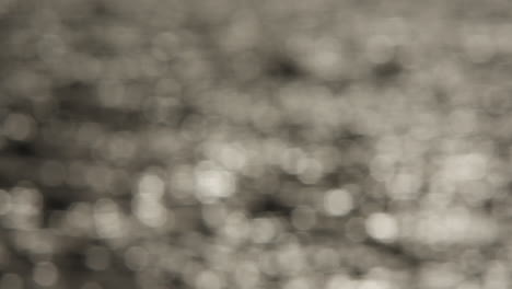 abstract grey sparkling background, out of focus sun on water