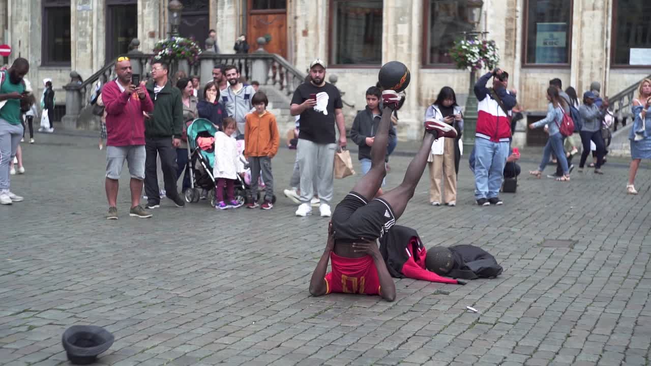 Man playing ball games in the middle of Brussels' Grand Place