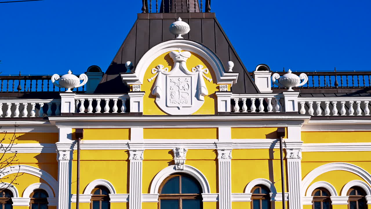 Discover the stunning features of a yellow historical building with intricate designs. Enjoy the clear blue sky and vibrant sunlight enhancing the beauty of this architectural gem