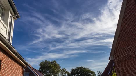 Thin White Clouds Blown By The Wind In The Blue Sky Over Residential Buildings On A Sunny Day - timelapse