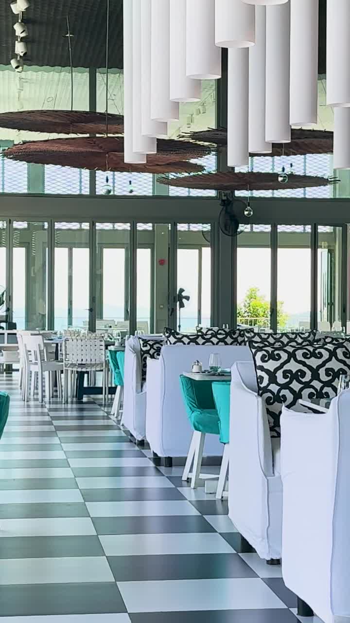 un lujoso restaurante en phuket, tailandia, que muestra un diseño moderno con acentos turquesa y iluminación natural