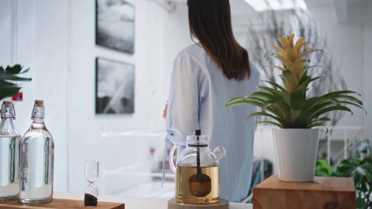 Hands holding tea cup in cozy kitchen. Peaceful woman enjoying home weekend