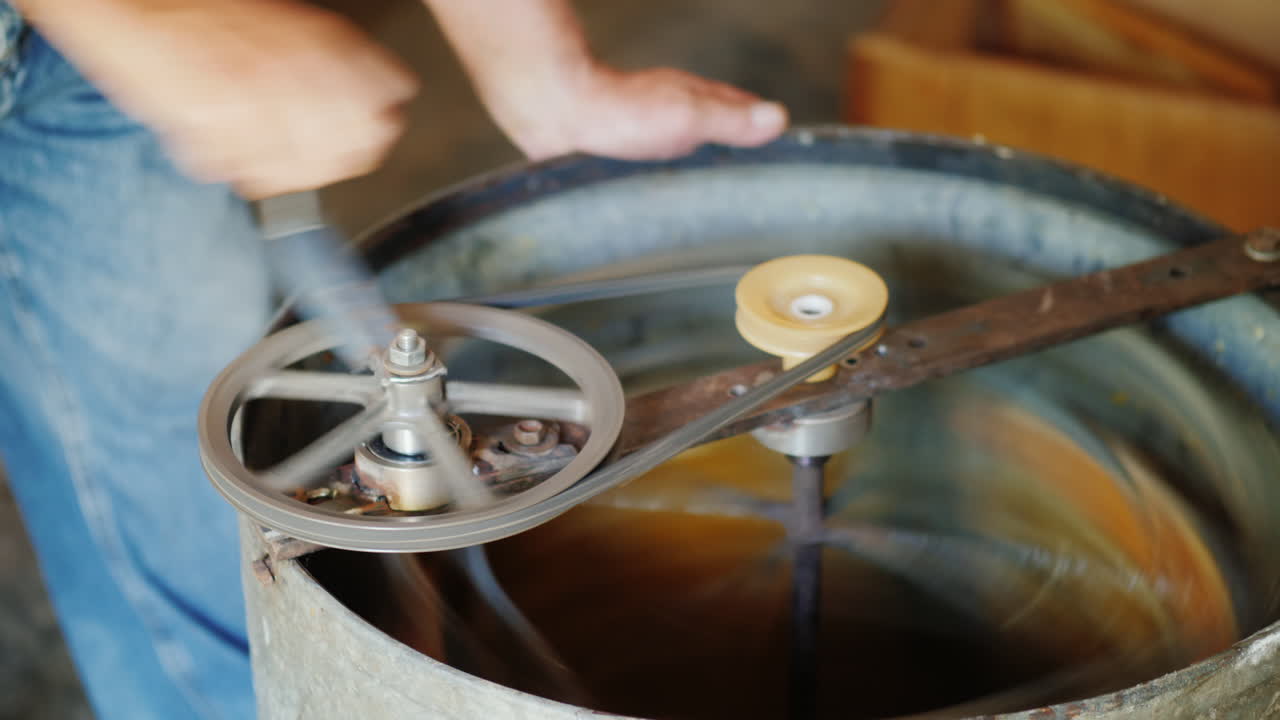 trabajo manual en el colmenar un hombre usa una máquina separadora para bombear miel 4k video