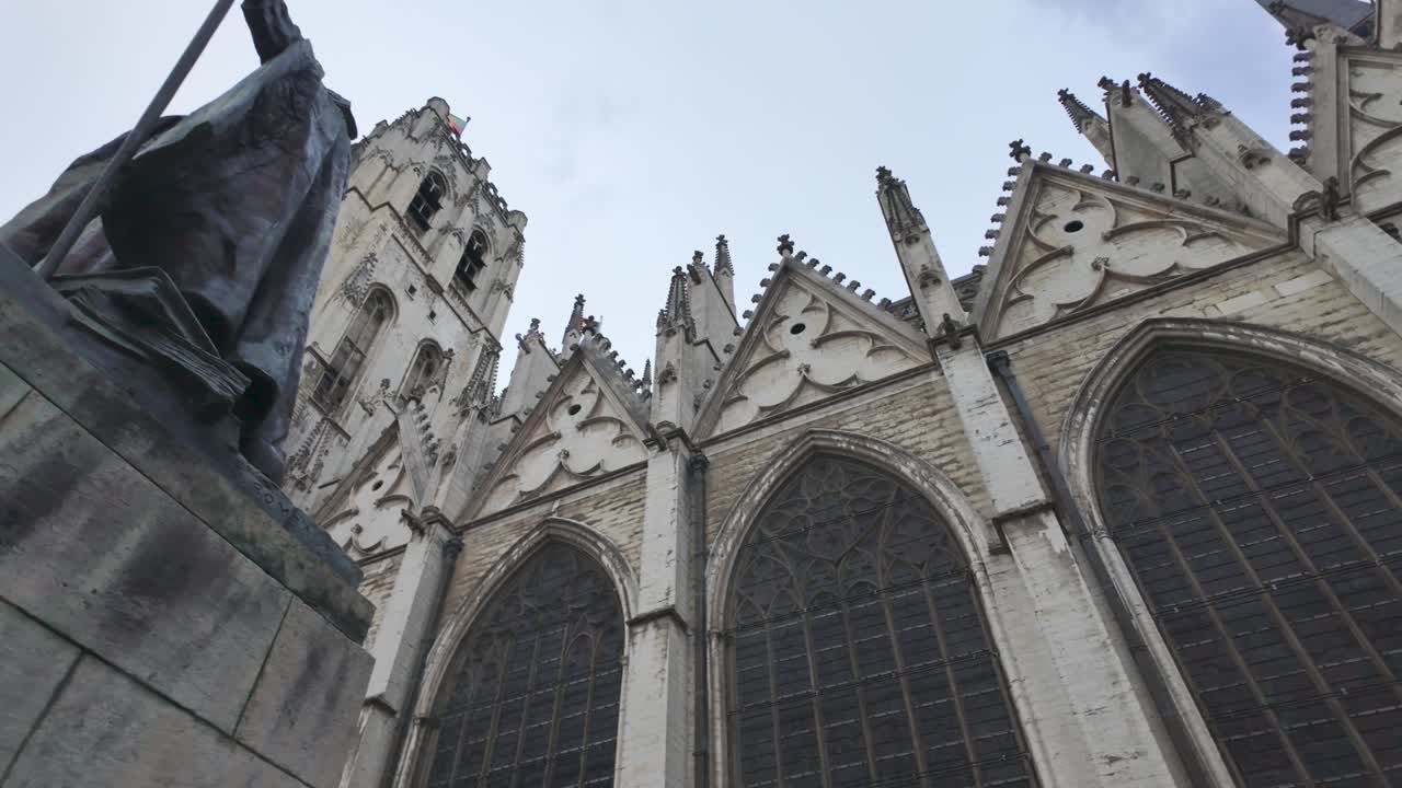 Impressive statue of Cardinal Mercier holding a staff, located in front of the majestic St. Michael and St. Gudula Cathedral in Brussels