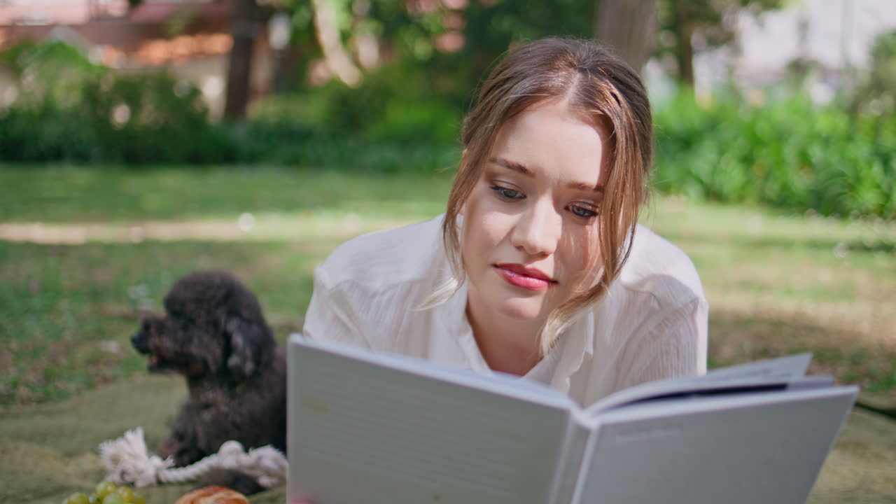 Closeup woman reading book relaxing at picnic with lovely dog. Relaxed lady