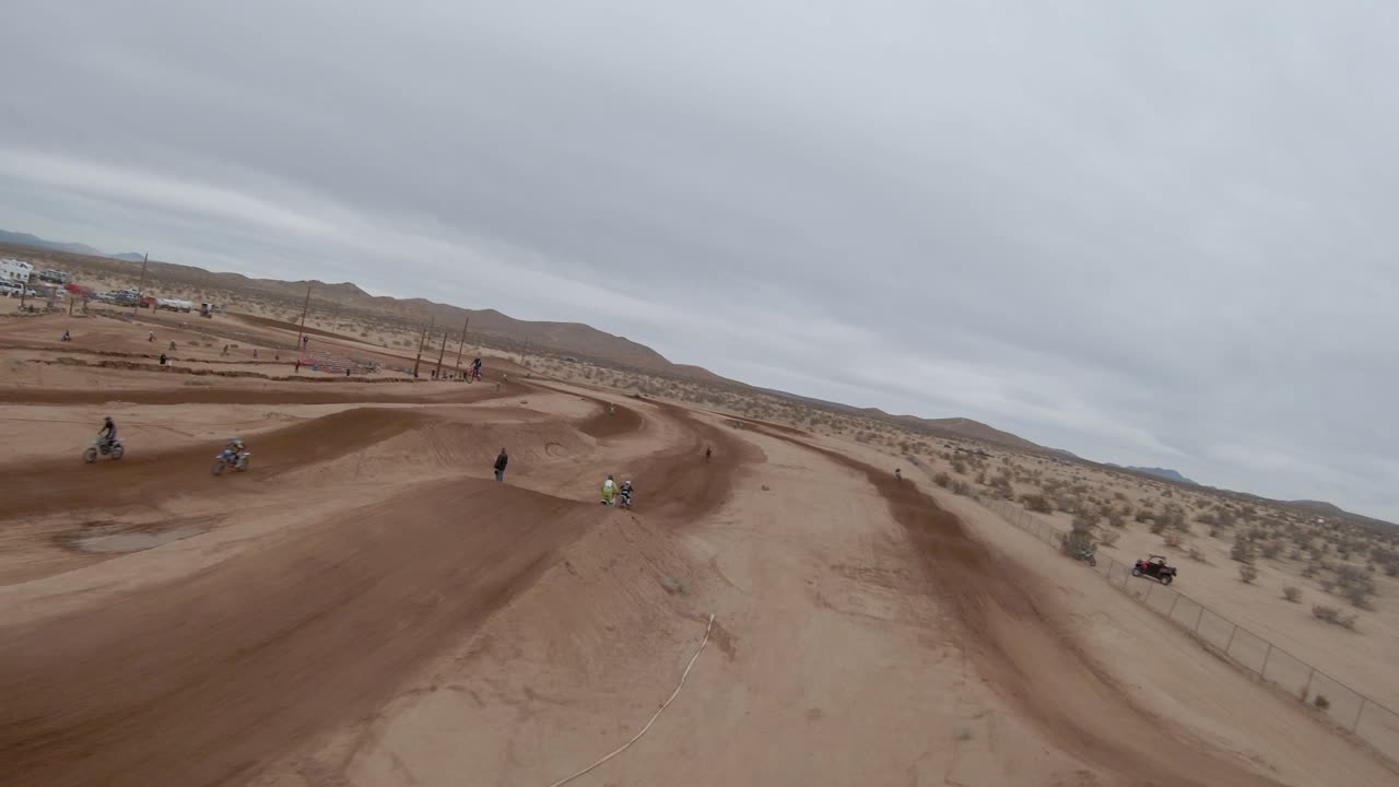 carreras de motocicletas en una pista de carreras fuera de carretera en el desierto de mojave - vista aérea en primera persona