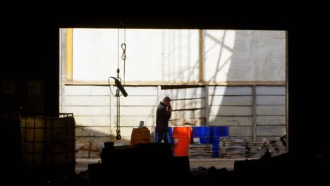 male worker talking on mobile phone in workshop 4k