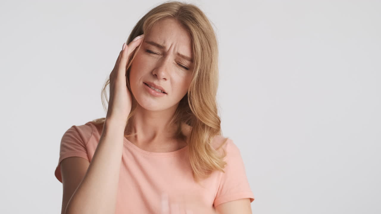 Caucasian woman showing headache on camera.