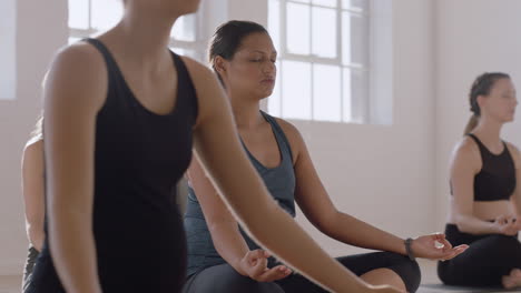 young-pregnant-mixed-race-woman-in-yoga-class-practicing-lotus-pose-enjoying-group-meditation-practice-relaxing-in-fitness-studio-at-sunrise