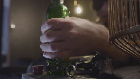 close up of drunk mans hand holding alcohol bottle