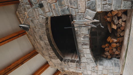 Stone restaurant barbecue firewood open brick oven cooking food dishes on fire indoors in backyard