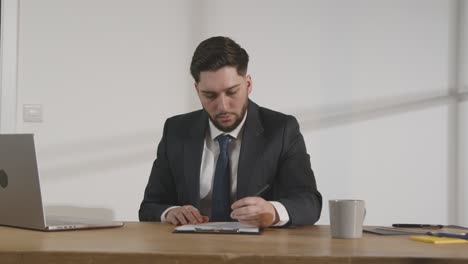 retrato de un hombre de negocios en el cargo revisando y tomando notas sobre la solicitud o el cv para la vacante de trabajo