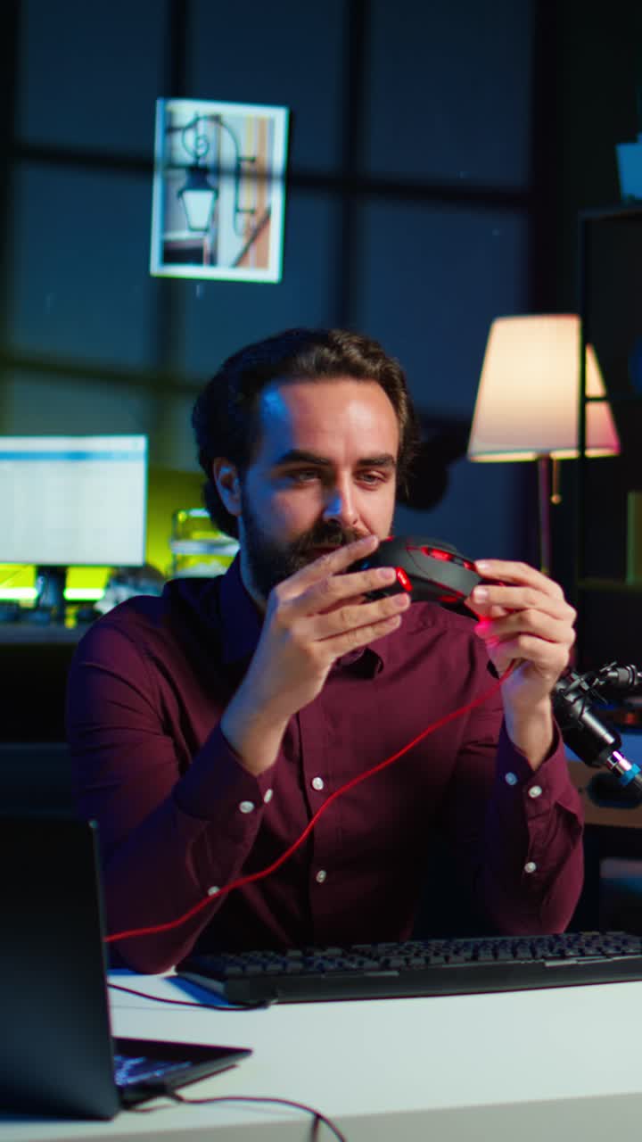 Video verticale. Un esperto di tecnologia testa cuffie, mouse e tastiera e li recensisce