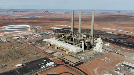 A-drone-shot-of-the-“Navajo-Generating-Station”,-a-massive-coal-fired-power-plant-and-industrial-complex-with-tall-stacks,-in-the-middle-of-the-desert-of-the-Navajo-Nation,-located-near-Page,-Arizona