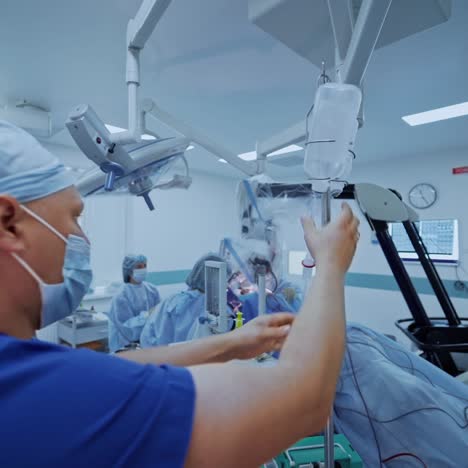 male assistant prepares medical equipment. group of doctors perform an operation. surgeons in medical uniform working in the operating room.