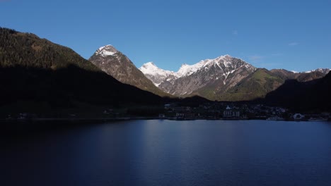 Sunrise-by-amazing-glacial-lake-Achensee-in-mountains-Alps-aerial-view-Pertisau